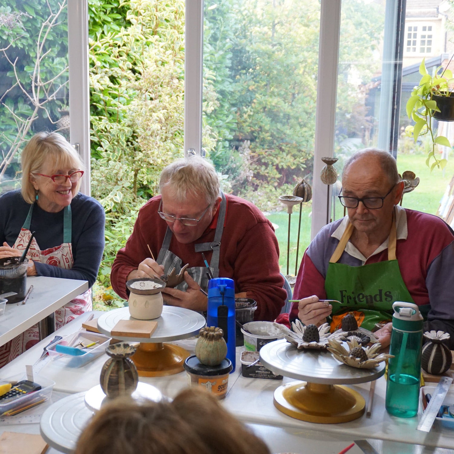 Students glazing their ceramic seed heads and flowers