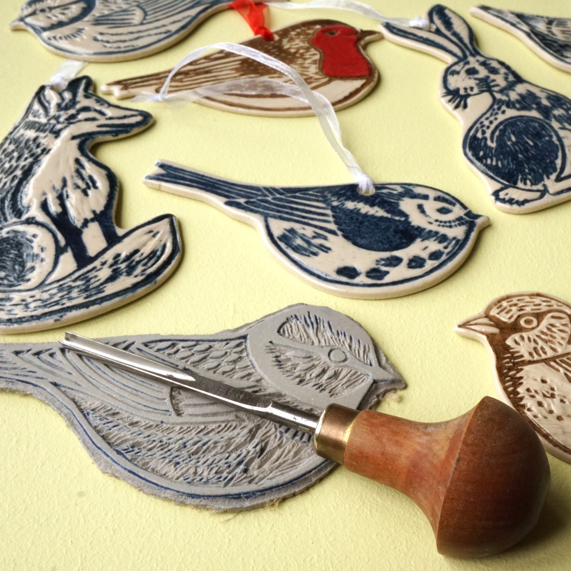 lino cutting tool, cut lino design of blue tit and finished hanging decorations