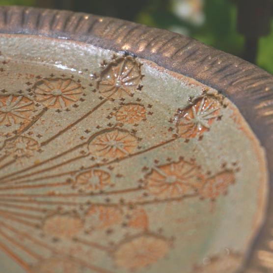 Close up of bird bath showing impressed textures, filled with water