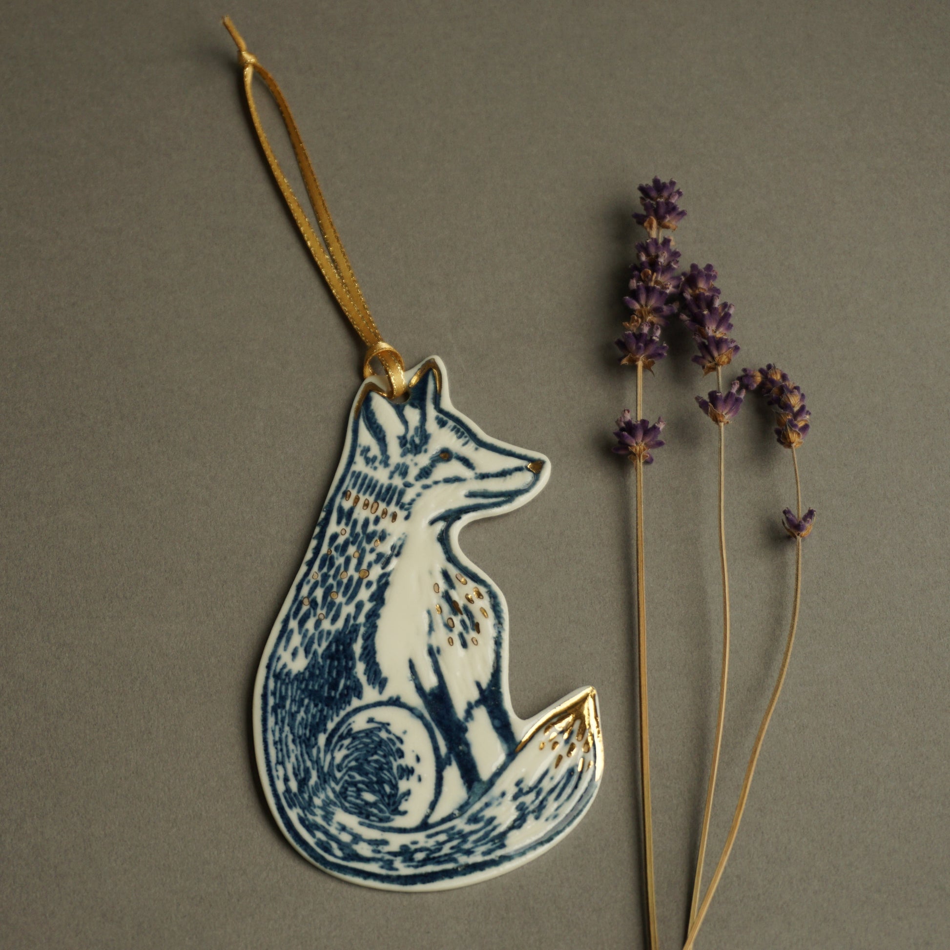 Porcelain Fox hanging decoration with gold lustre and gold ribbon, impressed with a hand carved lino cut to create the textured details.