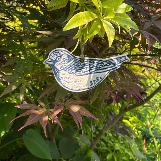 Sparrow ceramic hanging decoration hanging in tree with weathered organza ribbon turned moss green